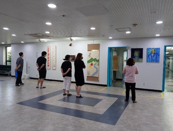 군포시청 2층 대회의실 입구에 전시돼있는 군포지역예술인들의 작품을 시민들이 감상하고 있다.